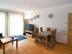 a living room with a table and chairs and a television at Modern Apartment near Forest in Heinrichskirchen in Heinrichskirchen