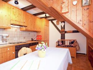 uma cozinha com armários de madeira e uma mesa com flores em Komfortable Ferienwohnung im Schwarzwald em Urberg