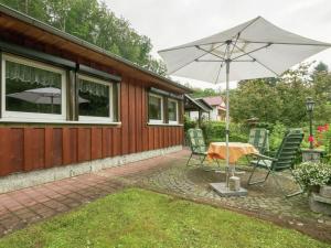 a patio with a table and an umbrella at Bungalow in Neustadt nahe Barbarossa Höhle in Neustadt