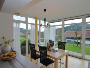 ein Esszimmer mit einem Tisch und Stühlen sowie großen Fenstern in der Unterkunft Apartment in Hauzenberg with private terrace in Hauzenberg