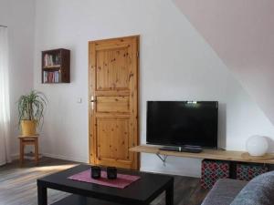 a living room with a flat screen tv and a table at Apartment in Tabarz Thuringia near the forest in Tabarz