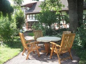 una mesa de madera, 2 sillas y una mesa en Apartment in Tabarz Thuringia near the forest, en Tabarz