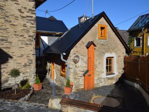 una pequeña casa de piedra con techo negro en cosy 1800 farmhouse with sauna, en Roes