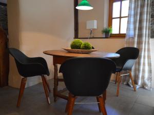 a dining room table with chairs and a bowl of fruit on it at cosy 1800 farmhouse with sauna in Roes