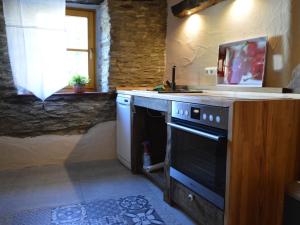 a kitchen with a stove and a sink and a window at cosy 1800 farmhouse with sauna in Roes