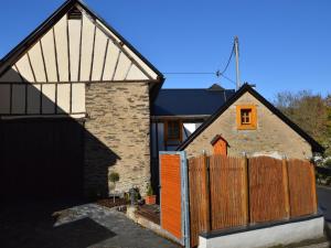 a barn conversion with an orange door and a wooden fence at cosy 1800 farmhouse with sauna in Roes