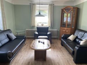 a living room with two leather couches and a coffee table at Spacious Apartment in Rodershausen with Barbecue in Rodershausen