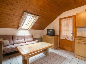 a living room with a couch and a tv at Delightful Holiday Home in Unterammergau in Unterammergau