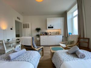 una camera d'albergo con due letti e una cucina di LOGIES-M Comfort Studios Inc Bikes B&B a Ostenda
