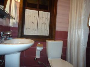 a bathroom with a toilet and a sink and a mirror at Hotel Klea in Berat