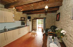 エイメにあるAwesome Home In Eymet With 1 Bedrooms And Outdoor Swimming Poolの石壁のキッチン(白いキャビネット付)