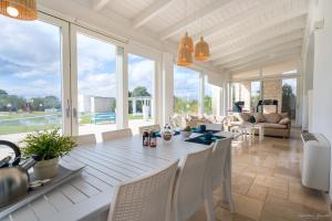 uma sala de jantar branca com uma mesa e cadeiras em Villa LUCI' in Puglia, vicina alla VALLE DI ITRIA em Mottola