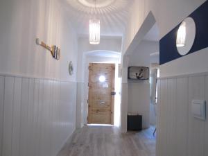 um corredor com uma porta de madeira num quarto em A Praia da Messejana em Messejana