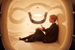 Une femme assise dans les toilettes d'un avion dans l'établissement Rembrandt Cabin Shinjuku Shin-Okubo, à Tokyo