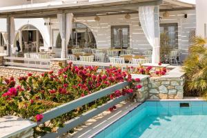a patio with flowers and a swimming pool at Paros Agnanti Hotel in Parikia
