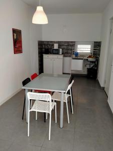 uma cozinha com mesa e cadeiras num quarto em Eleonora Bed and breakfast em Muscoline