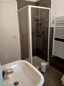 uma casa de banho com um chuveiro e um lavatório branco em Eleonora Bed and breakfast em Muscoline