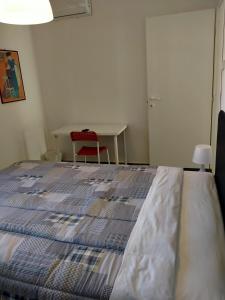 uma cama num quarto com uma mesa e uma cadeira vermelha em Eleonora Bed and breakfast em Muscoline