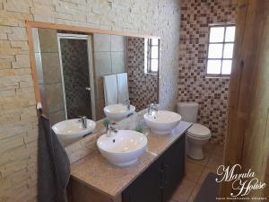 a bathroom with three sinks and a mirror at Moritshane estate in Gaborone