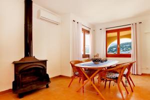 uma sala de jantar com uma mesa e um fogão a lenha em Es Faro House by Slow Villas em Port de Sóller