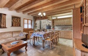 a kitchen and living room with a table and a couch at Alle Sorgenti in Comeglians