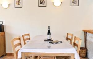 einen Esstisch mit einer Flasche Wein darauf in der Unterkunft 2 Bedroom Awesome Home In Brucheville in Brucheville