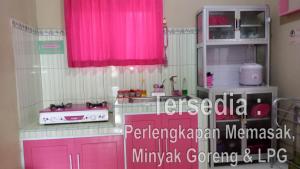 a kitchen with pink cabinets and a pink window at Kanalan Homestay Banyuwangi in Banyuwangi