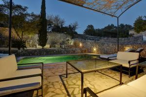 a patio with a table and chairs and a pool at Villa Can Pulit by Slow Villas in El Port de la Selva +36 photos