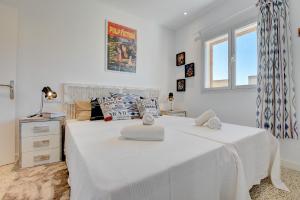 1 dormitorio con 1 cama con sábanas blancas y ventana en Villa Can Benet de sa Cubana by Slow Villas, en Calviá
