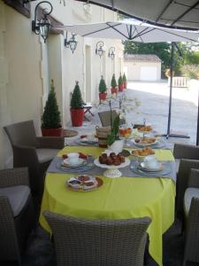 uma mesa com pratos de comida numa toalha de mesa amarela em Le Moulin du Galant em Ménesplet