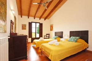 2 camas en una habitación con sábanas amarillas en Villa Es Bosquet by Slow Villas, en Crestatx