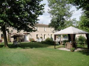 un patio con una sombrilla blanca y una casa en Le Moulin du Galant, en Ménesplet
