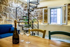 - une bouteille de vin sur une table en bois avec 2 verres dans l'établissement Alguer Relais, à Alghero