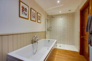 a white bath tub in a bathroom with a brick wall at Home Farm B&B - Sunflower Room in Forfar