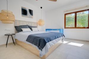 a bedroom with a large bed in a white room at Villa Roca Verde by Slow Villas in Puigpunyent