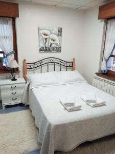 a bedroom with a bed with two towels on it at Apartamento Valle del Güeña in Benia de Onís