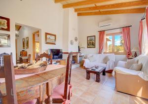 a living room with a couch and a table at Villa Cas Frares by Slow Villas in Santa Maria del Camí