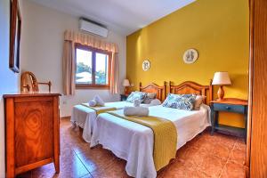 リュックマヨールにあるVilla Segundo by Slow Villasの黄色い壁の客室内のベッド2台