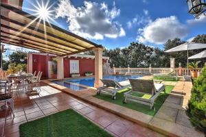 a patio with a pool and chairs and an umbrella at Villa Segundo by Slow Villas in Llucmajor