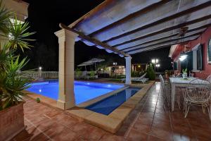 a patio with a pool and a pergola at night at Villa Segundo by Slow Villas in Llucmajor