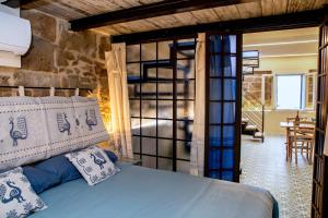 - une chambre avec un lit et une porte en verre dans l'établissement Alguer Relais, à Alghero