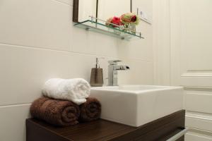 ein Badezimmer mit Waschbecken, Spiegel und Handtüchern in der Unterkunft Royal Prague Apartment Celakovskeho Sady in Prag + 25 Fotos