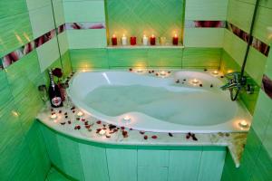 a bathroom with a tub with candles in it at Sunlion Баунти Hotel in Sochi