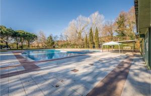 einen Pool mit einem Tisch und einem weißen Sonnenschirm in der Unterkunft Cozy Home In Puig Ventos With Outdoor Swimming Pool in Mont Barbat