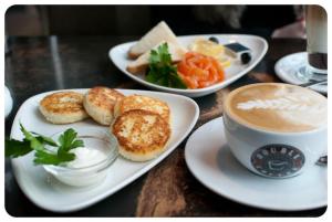 a table with plates of food and a cup of coffee at Sputnik in Kirov