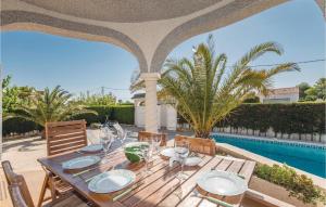 uma mesa de madeira com copos de vinho num pátio em Amazing Home In Lametlla De Mar With Swimming Pool em Les tres Cales