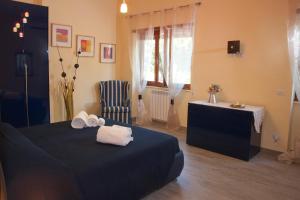 a bedroom with a bed and a chair and a window at Domus in Viridi in Rome