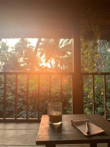 a glass of tea sitting on a table on a porch at The Sunset Chalet in Anjuna +27 photos