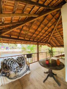 a patio with a table and chairs on a porch at The Sunset Chalet! in Anjuna