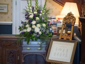 a bouquet of flowers on top of a wooden table at Kincaid House Hotel in Kirkintilloch